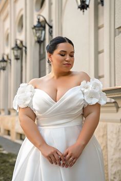 a woman in a white dress standing outside