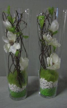 two vases with flowers and rocks in them