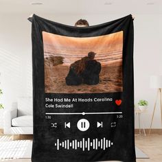 a black blanket with an image of a woman sitting on the ground and listening to music