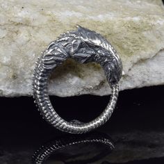 Enter the surreal world of H.R. Giger with our handcrafted silver Alien Newborn Ring Chestburster--a collector's item with a unique design inspired by the iconic extraterrestrial creature. Crafted in sterling silver, this statement ring captures the essence of sci-fi and pop culture, making it an unconventional and stylish accessory for collectors and enthusiasts. Alien Ring, Sci Fi Jewelry, Index Finger Rings, Unique Jewelry Designs, Stylish Accessories, Band Rings, Science Fiction, Pop Culture, Statement Rings