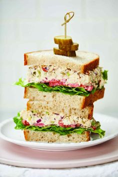 two sandwiches stacked on top of each other with lettuce and meat in the middle