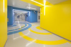 an empty hallway with yellow and blue paint on the walls, white floors and flooring