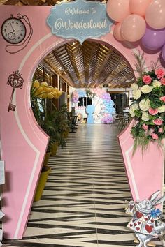 the entrance to wonderlandland is decorated in pink and white with balloons hanging from the ceiling