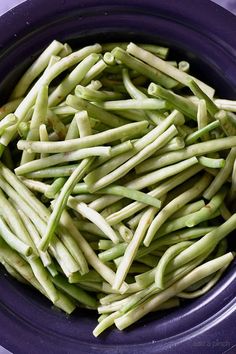 a bowl filled with green beans covered in sauce