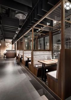 an empty restaurant with wooden booths and tables