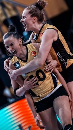 two female volleyball players are hugging each other