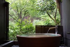 a large bath tub sitting in the middle of a room next to a wooden bench