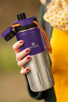 a woman holding a purple and silver water bottle