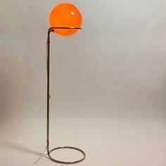 an orange ball is on top of a metal stand