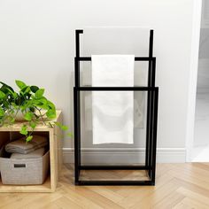 a stack of towels sitting on top of a wooden shelf next to a plant