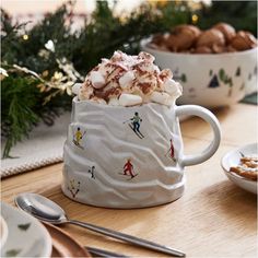 a cup filled with hot chocolate and marshmallows on top of a table