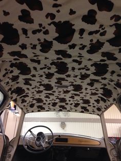 the interior of an old car with cow print covering it's ceiling and dash board