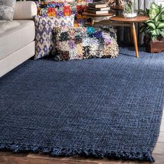 a living room with a blue rug on the floor next to a couch and coffee table