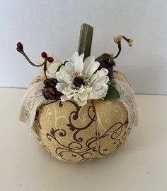 a decorative pumpkin decorated with flowers and ribbons