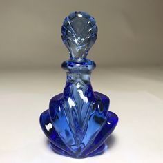 a blue glass perfume bottle sitting on top of a table