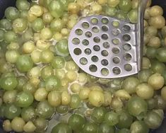 grapes being cooked in a pot with a grater