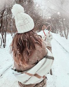 a woman holding a candy cane in the snow