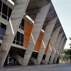 the building is made out of concrete and has orange panels on it's sides