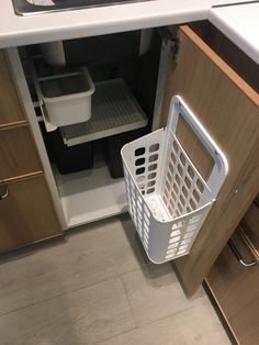 a white basket sitting in the middle of a kitchen cabinet