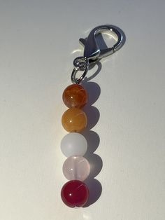 a close up of a key chain with beads on it's end and an object in the middle