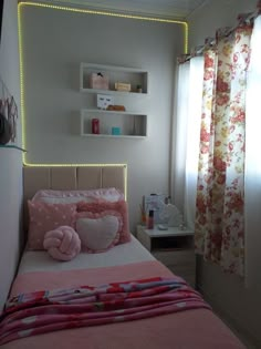 a small bedroom with pink and white decor