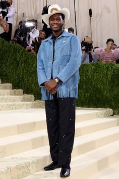 a man in a cowboy hat standing on steps