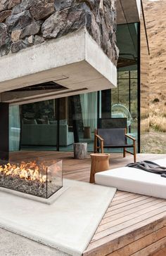 a fire pit sitting on top of a wooden deck next to a chair and table