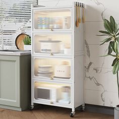 a white cabinet sitting next to a potted plant