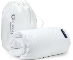 a white sleeping bag next to an unzipped pillow on a white background with the words live love printed on it