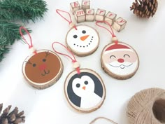 three ornaments are hanging on the table next to pine cones and twined twine