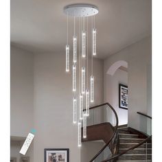 a chandelier hanging from the ceiling in a living room next to a stair case