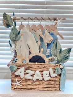 a wicker basket filled with baby clothes and personalized letters that spell out the word sale