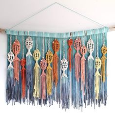 a wall hanging with tassels and hearts on it