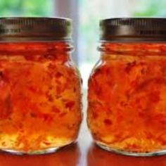 two jars filled with jam sitting on top of a table