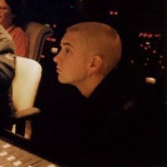 a man sitting in front of a computer keyboard next to another person at a desk