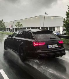 a black car driving down a wet road