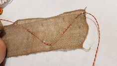 someone is stitching together some burlap and twine to make an ornament