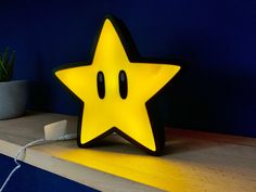 a yellow star shaped light sitting on top of a wooden shelf