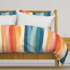 a bed with two pillows on top of it next to a wooden headboard and foot board