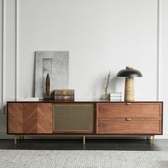 the sideboard is made out of wood and has two lamps on top of it