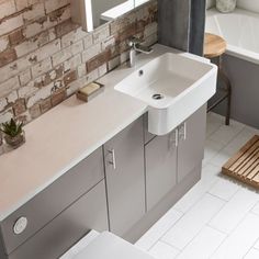 a white sink sitting next to a bath tub in a bathroom