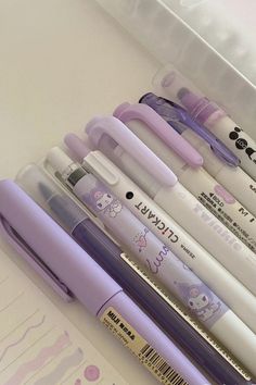 several pens are lined up in a plastic container