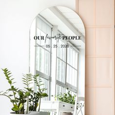 a mirror sitting on top of a table next to a potted plant