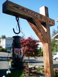 a wooden cross with a lantern hanging from it