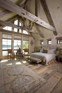 a large bedroom with stone walls and wooden beams on the ceiling, along with an area rug that looks like it has been made out of wood