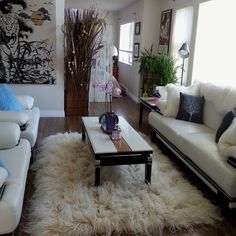 a living room filled with white couches and pillows