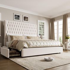 a white bed sitting on top of a hard wood floor next to a window with curtains