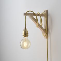 a light that is on the wall next to a lamp shade and some cords attached to it