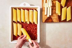 a person is cutting up some pasta in a pan on a table with other ingredients