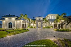 a large house with palm trees in the front yard and landscaping around it at night